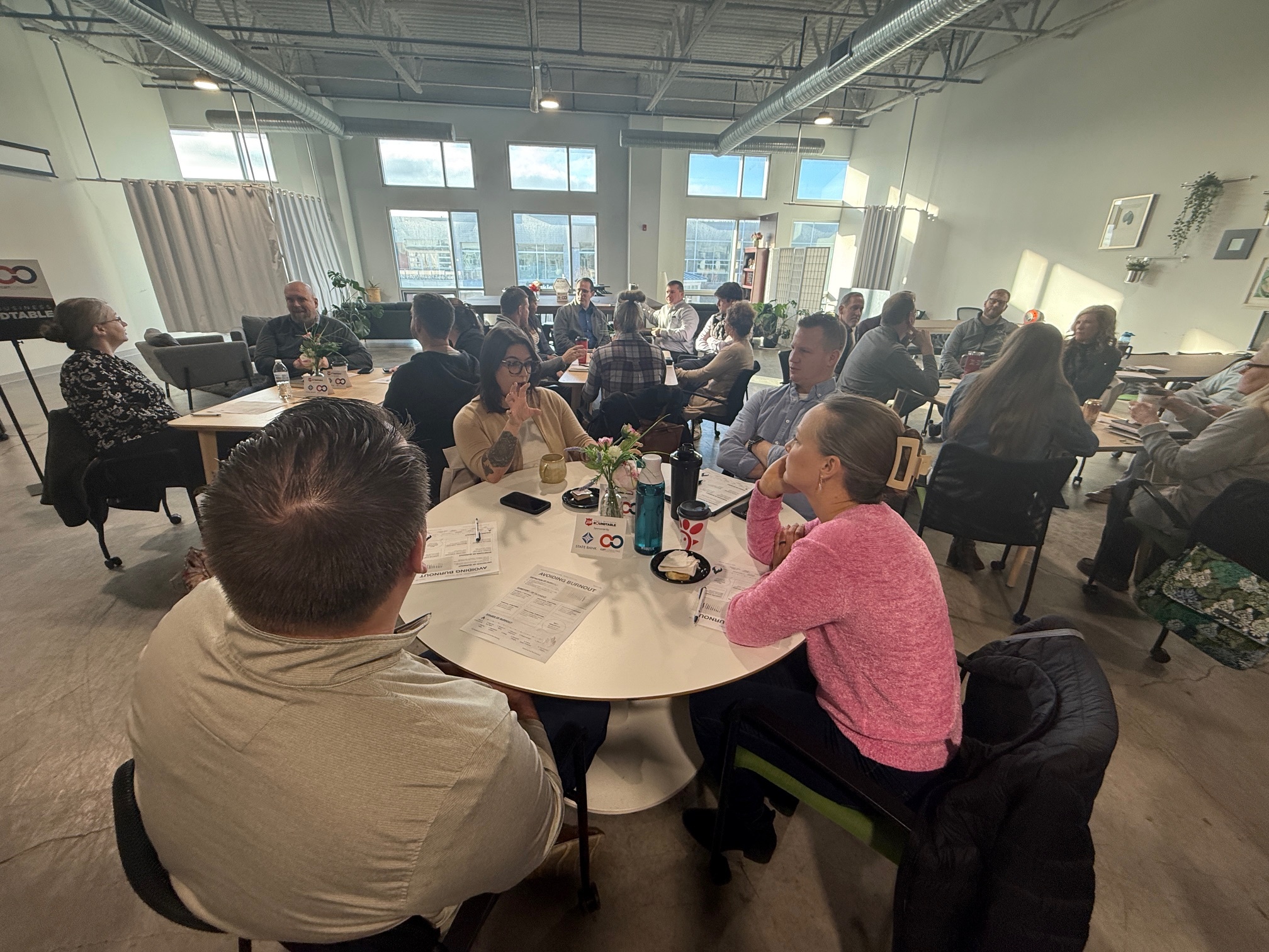 Image of professionals sitting at tables discussing networking topics.